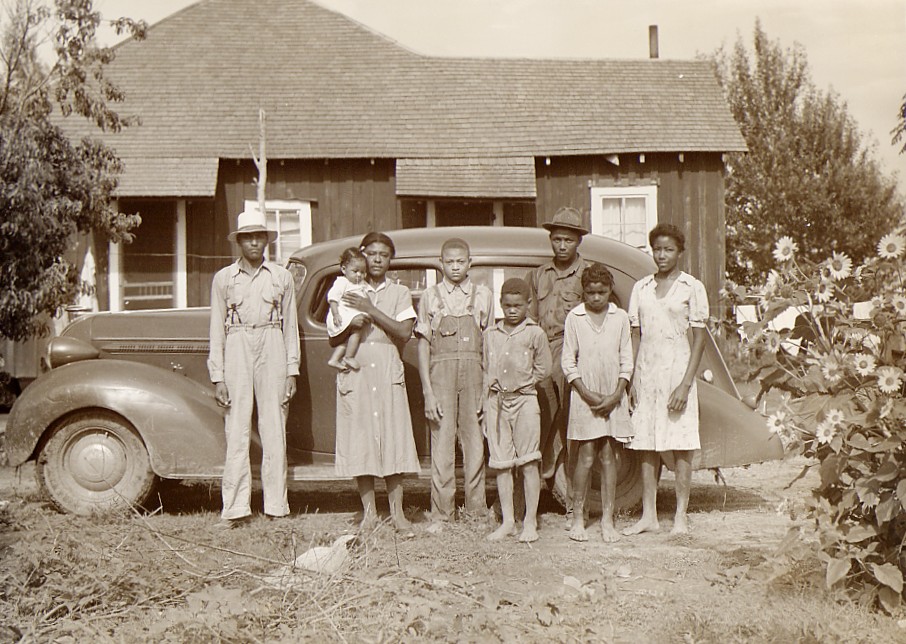 african american family posing front of home